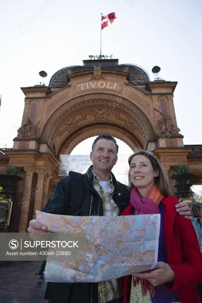 Couple with map sightseeing near arch