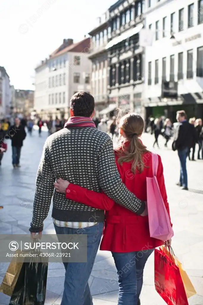 Couple with shopping bags, walking in city