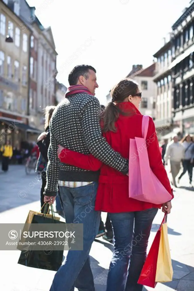 Couple with shopping bags, walking in city