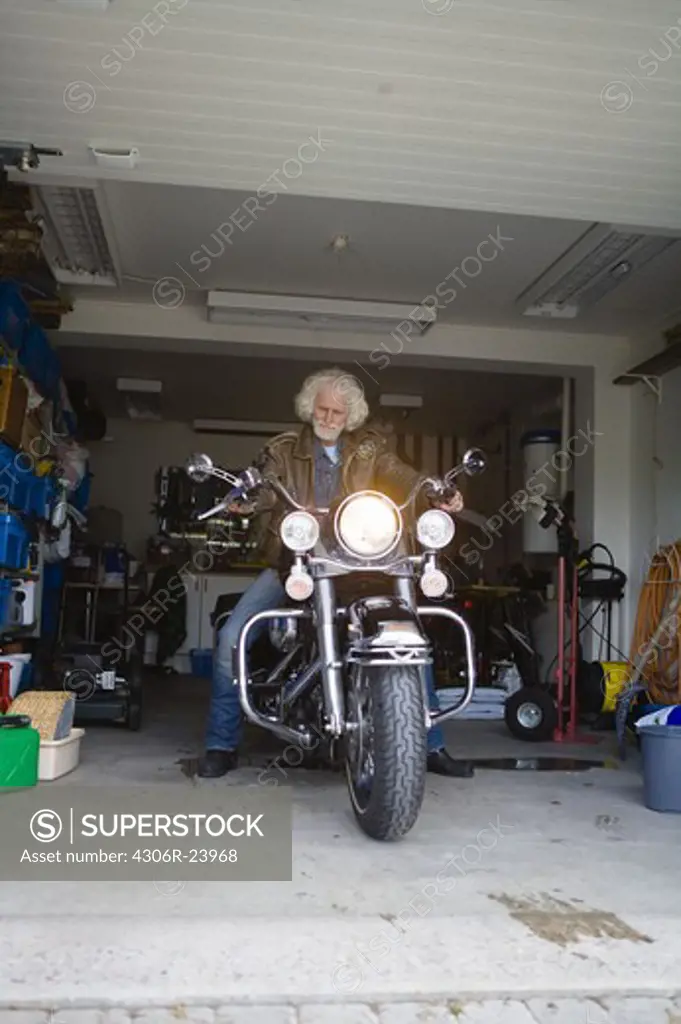 Man on vintage motorbike in garage