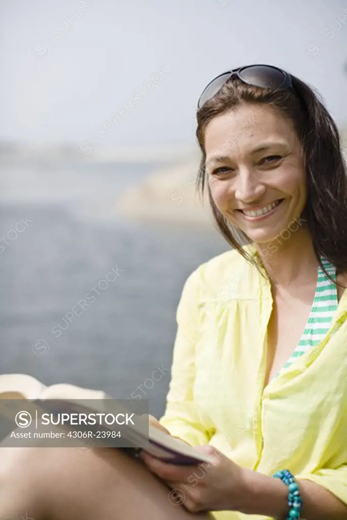 Woman reading book, smiling