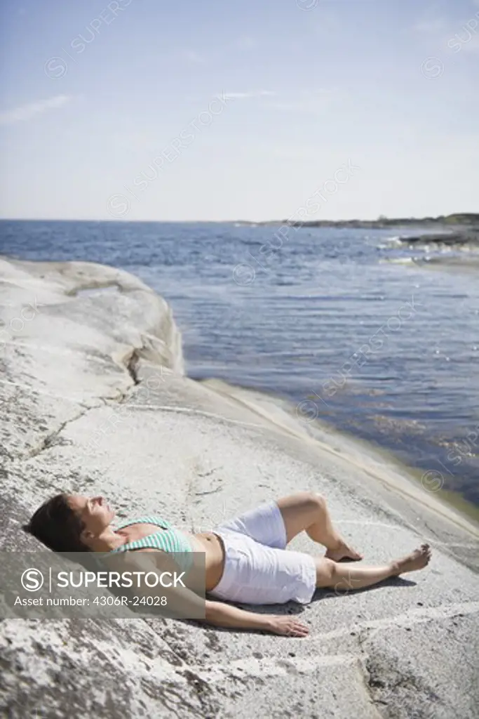 Woman lying on rock