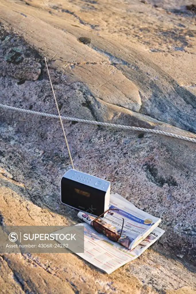 Rope tied on cliff with transistor and newspaper