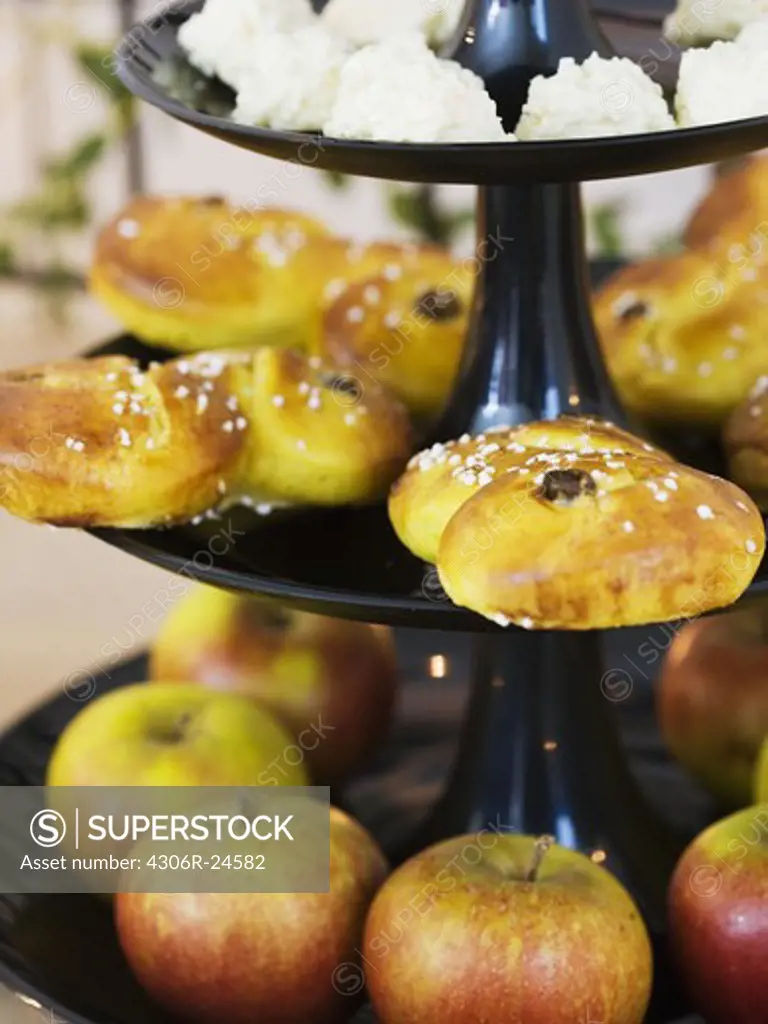 Apples and saffron rolls on cakestand, close-up