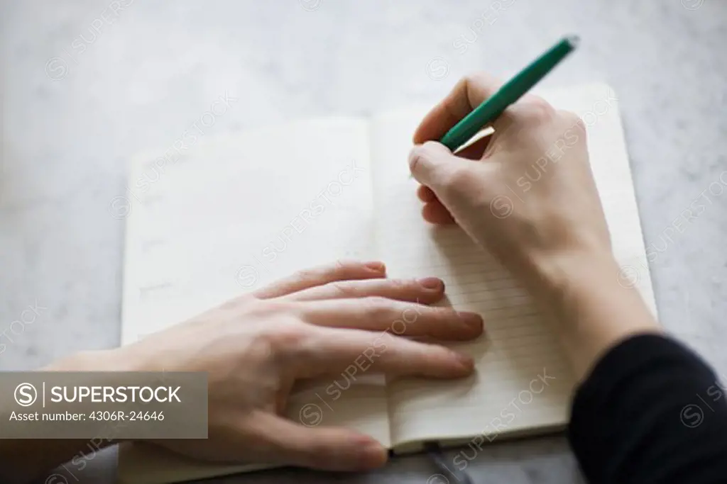 Woman writing on diary