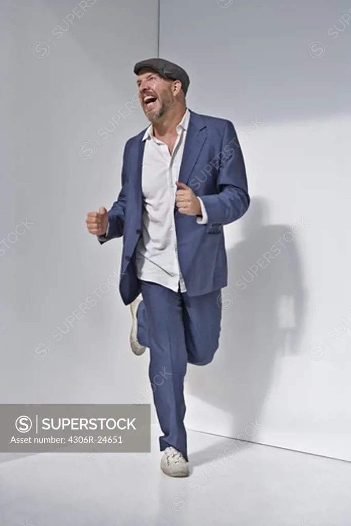 Man laughing and running against white background