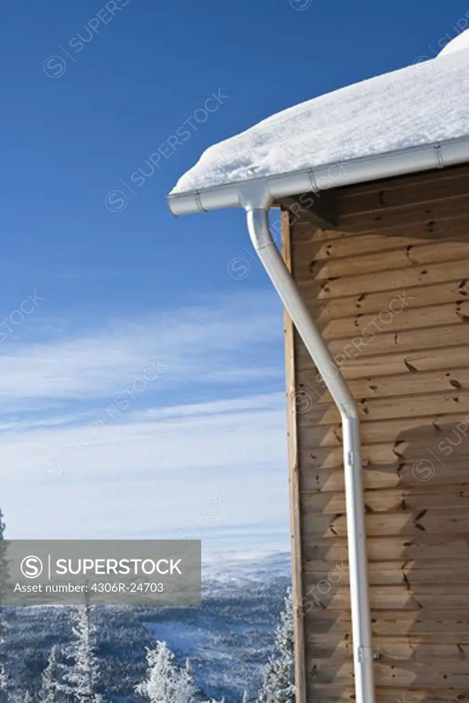 Wooden house covered by snow
