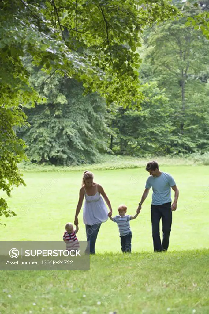Mid adult couple with children walking in park
