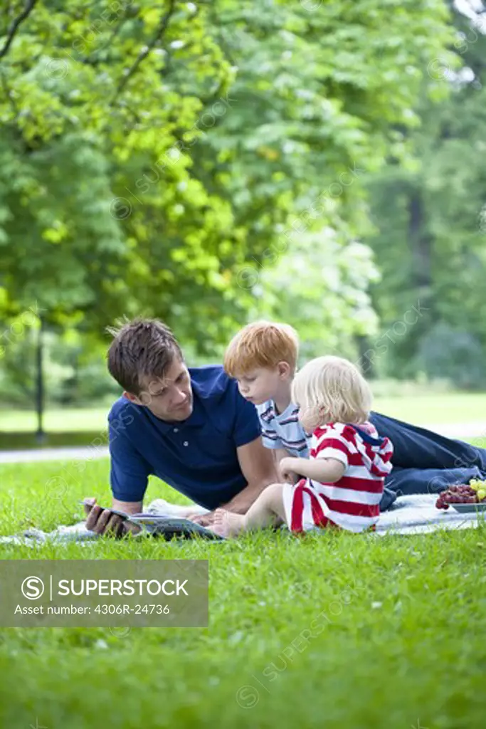 Mid adult father reading  book to children