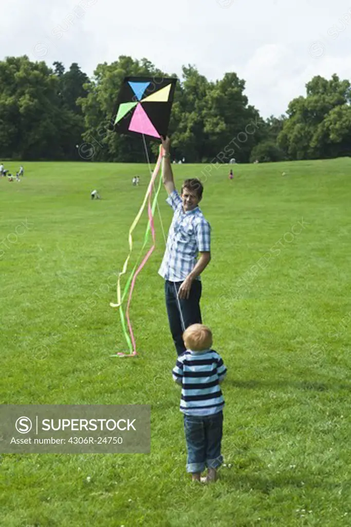 father with son playing with kite