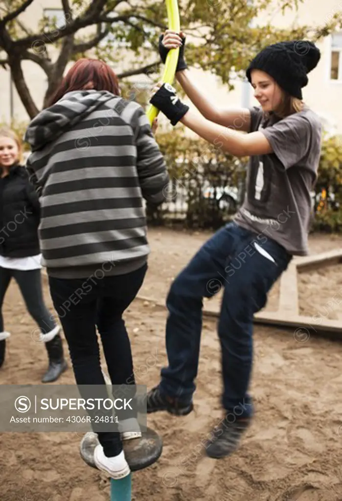 Teenagers playing on jungle gym in schoolyard