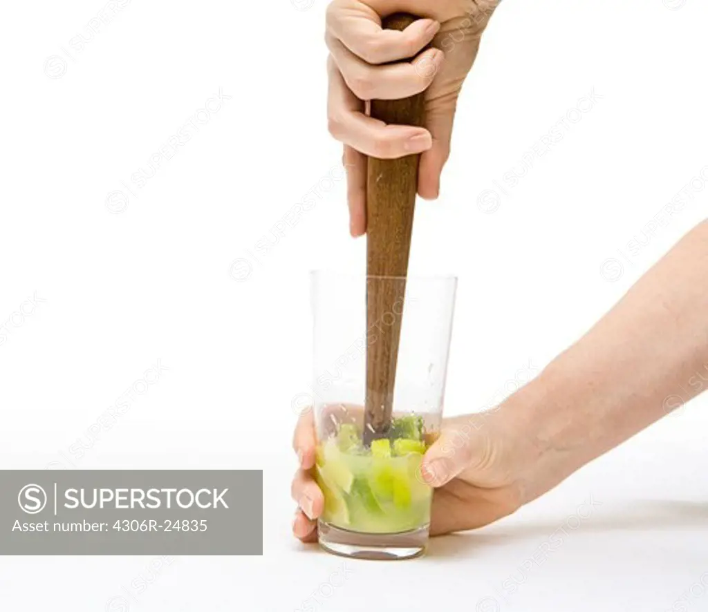 Hand crushing lemons in glass