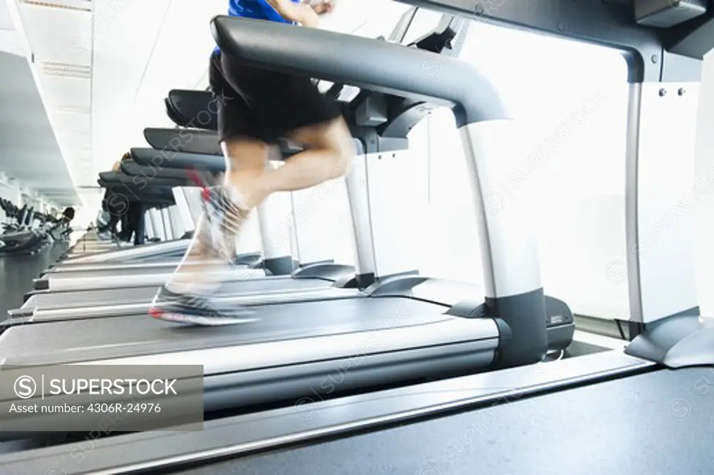 Man running on treadmill in gym