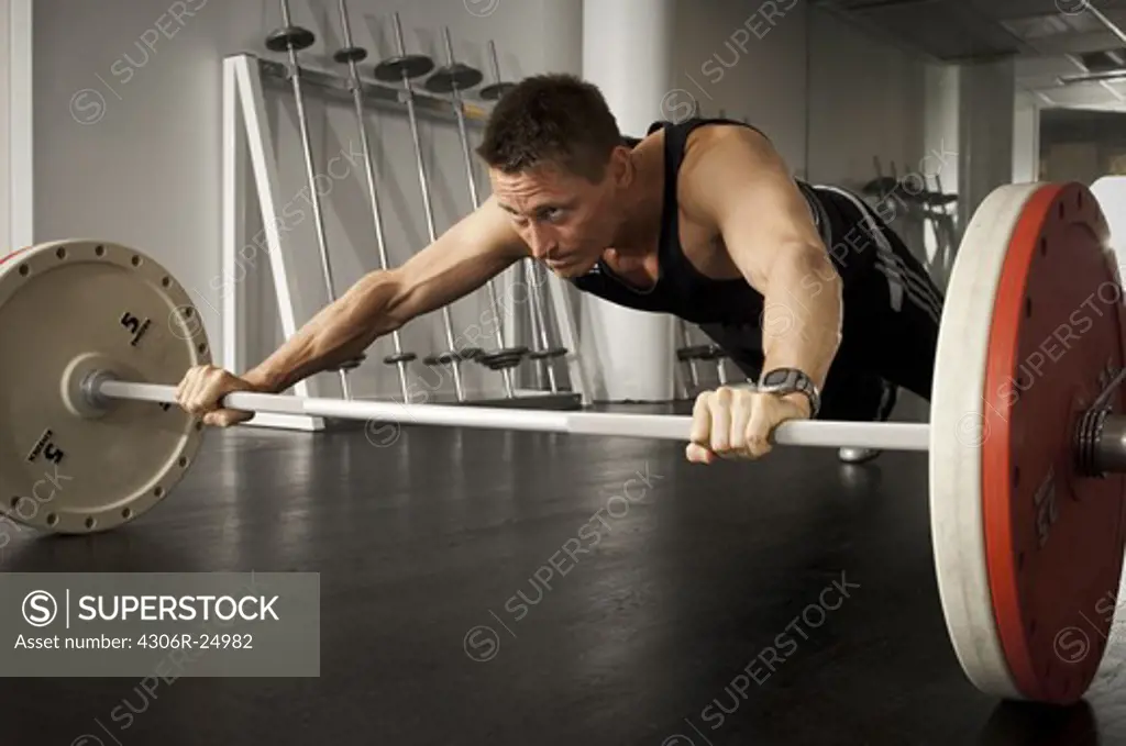 Male athlete holding barbell in gym