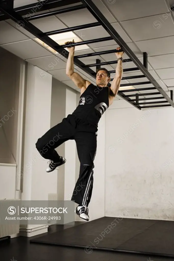 Male athlete using gymnastics equipment in gym
