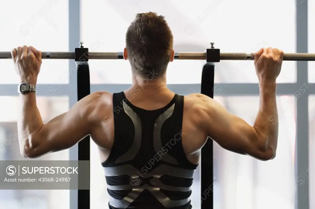 Male athlete doing pull ups in gym