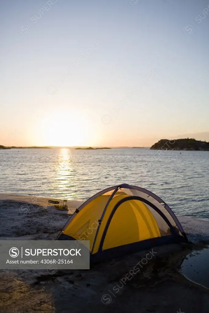 Tent by sea at sunset