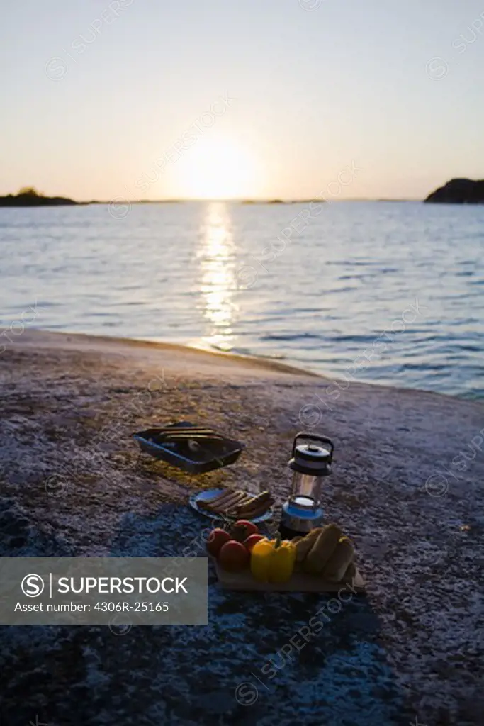 Barbecue equipment by sea at sunset