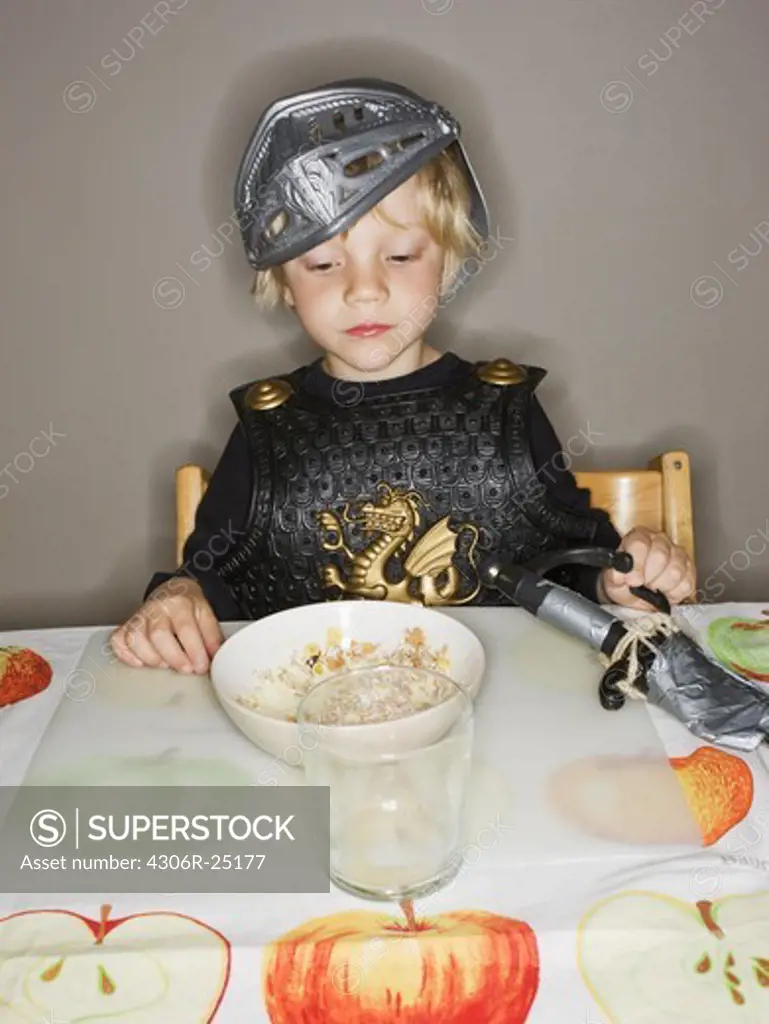 Boy in armour suit looking at breakfast