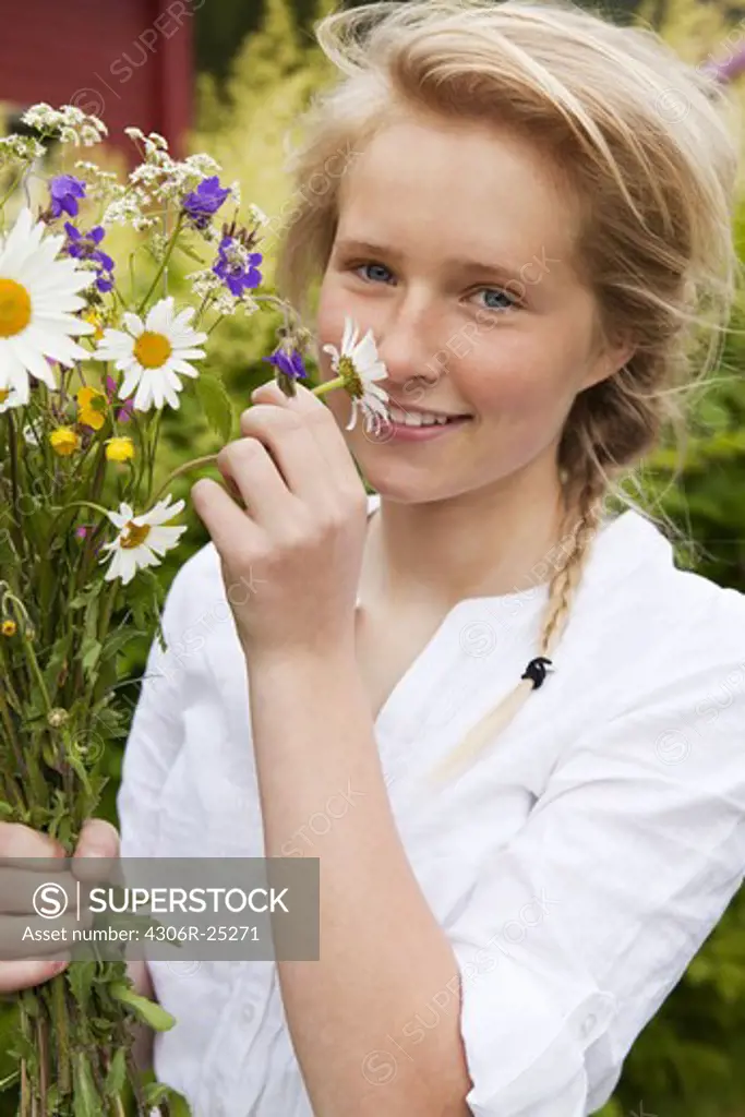 Portrait of teenage girl with bunch of flowers