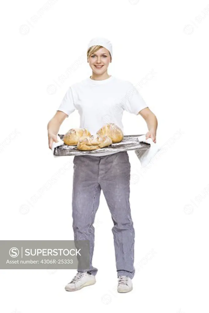 Woman holding baking tray with bread, smiling, portrait