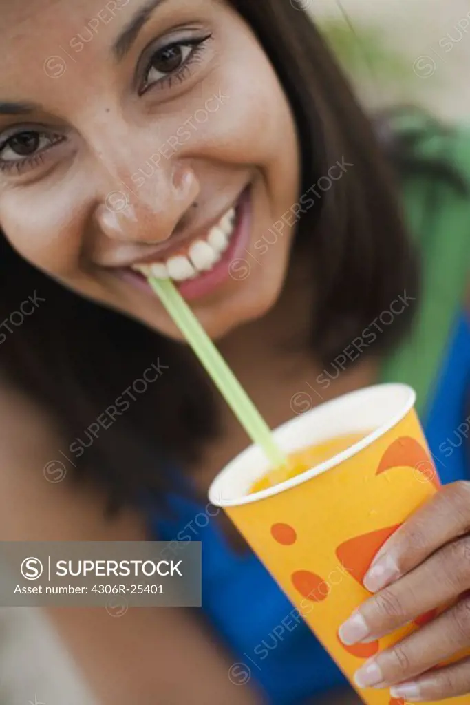 Portrait of woman drinking ice cold drink
