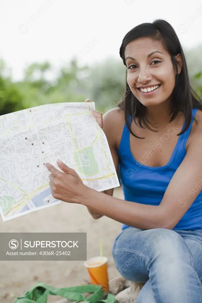 Portrait of woman pointing at map