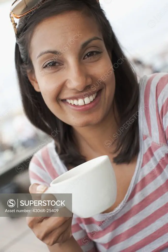 Portrait of woman holding coffee cup outdoors
