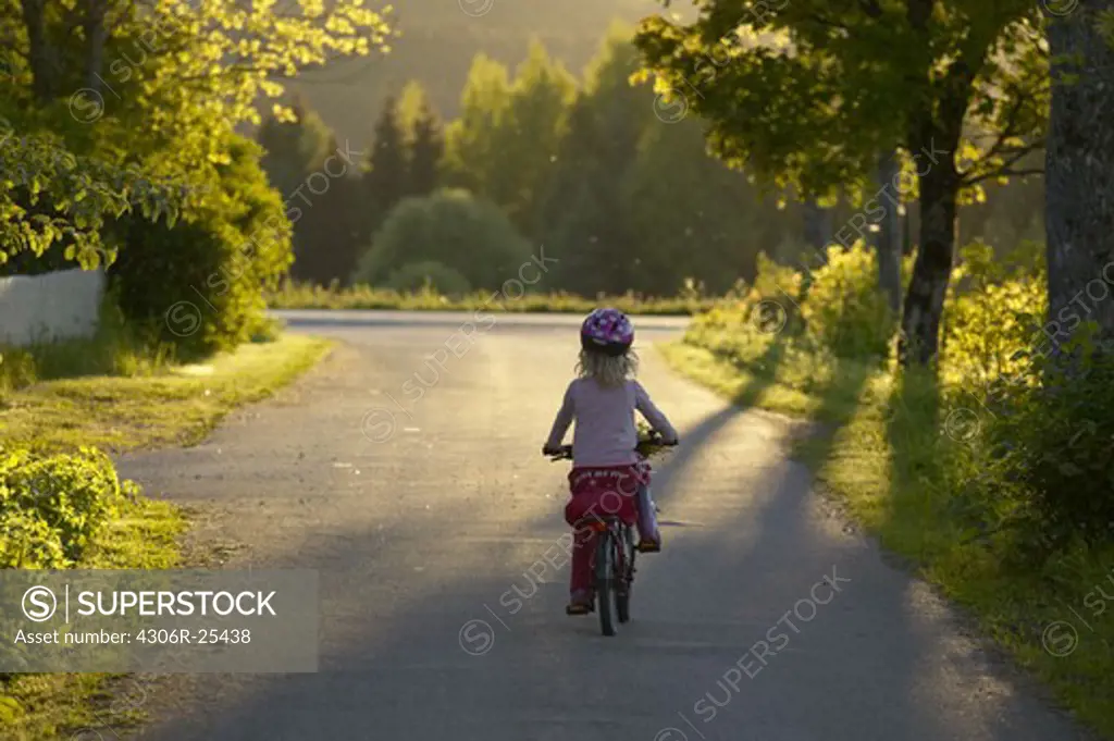 Girl riding bicycle on country road