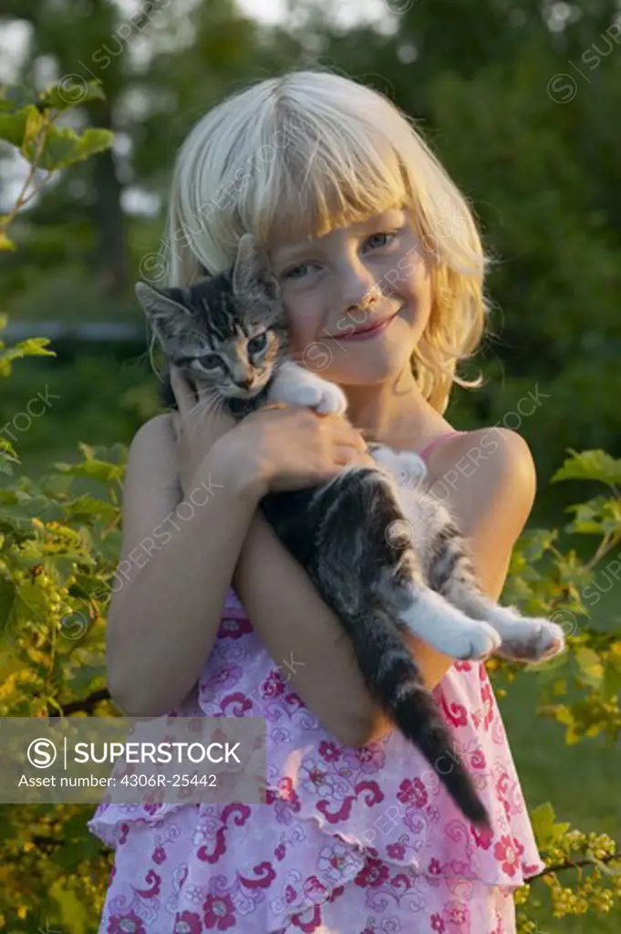 Portrait of girl embracing cat outdoors