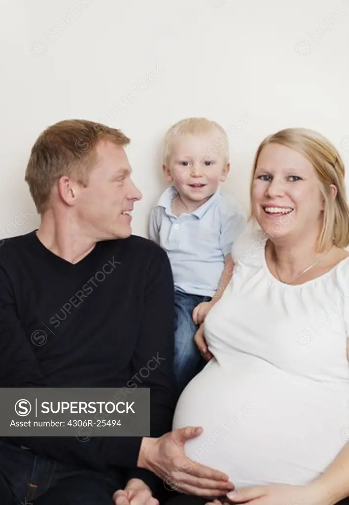 Mid adult couple with son sitting on sofa