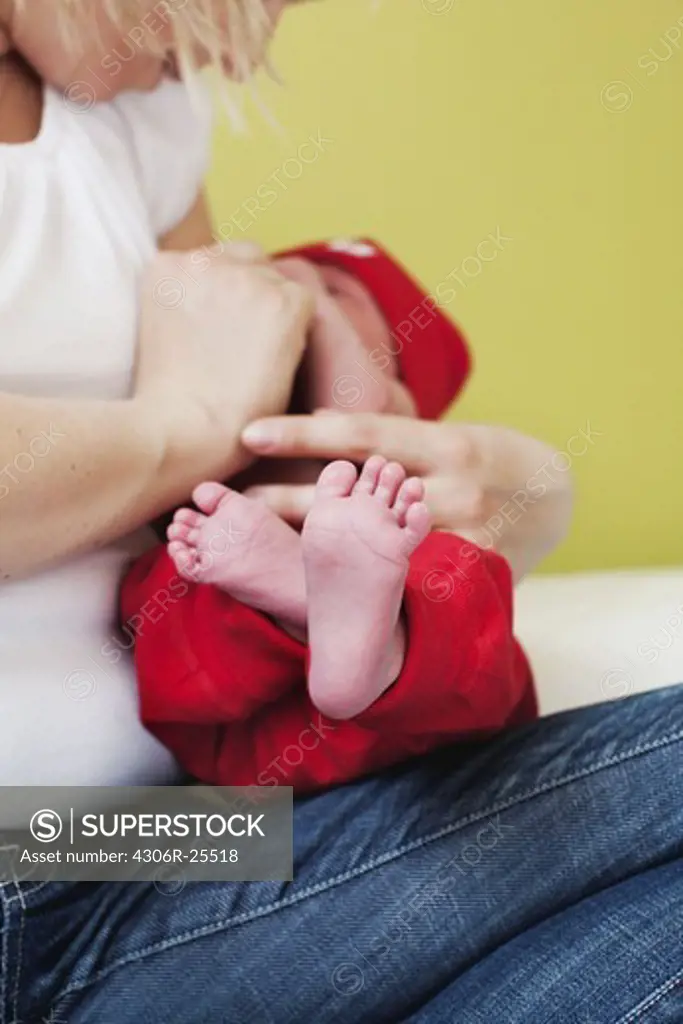 Mid adult woman holding newborn child