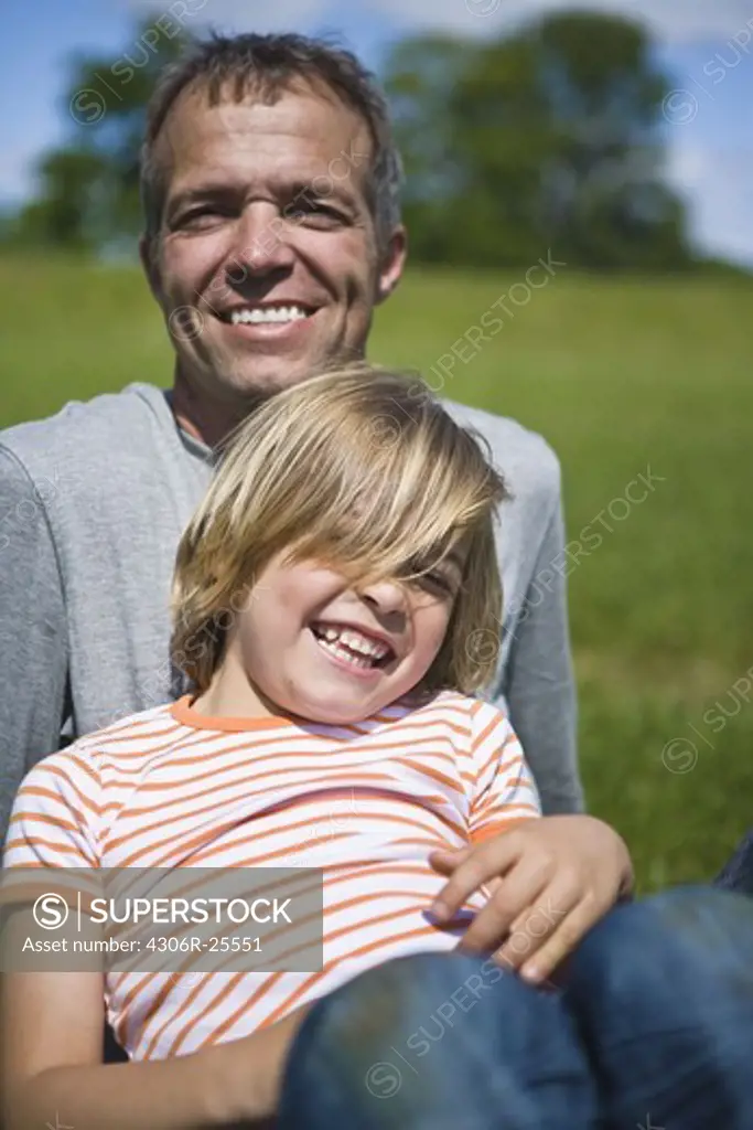 Portrait of father with son looking at camera and laughing
