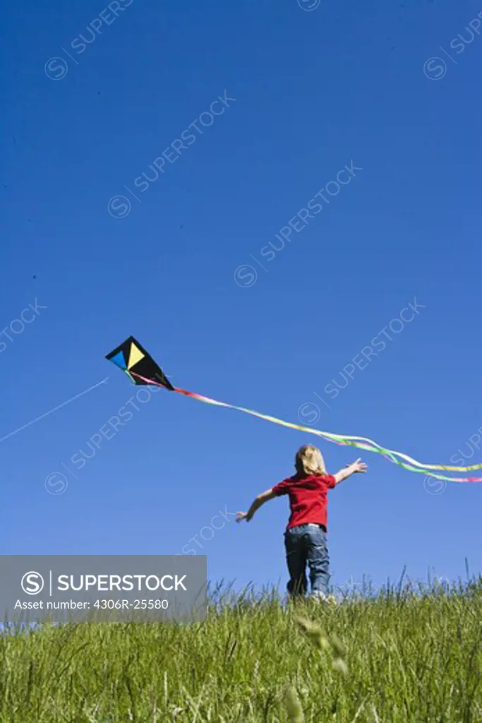 Boy running after kite