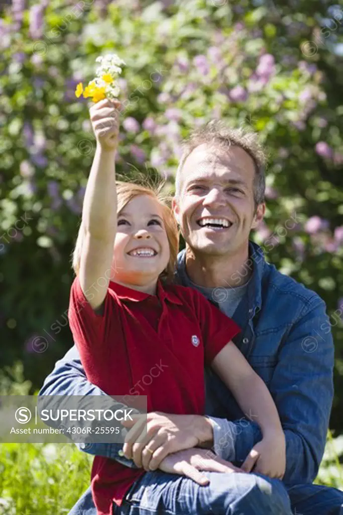 Father and son with flowers, in bright sunlight
