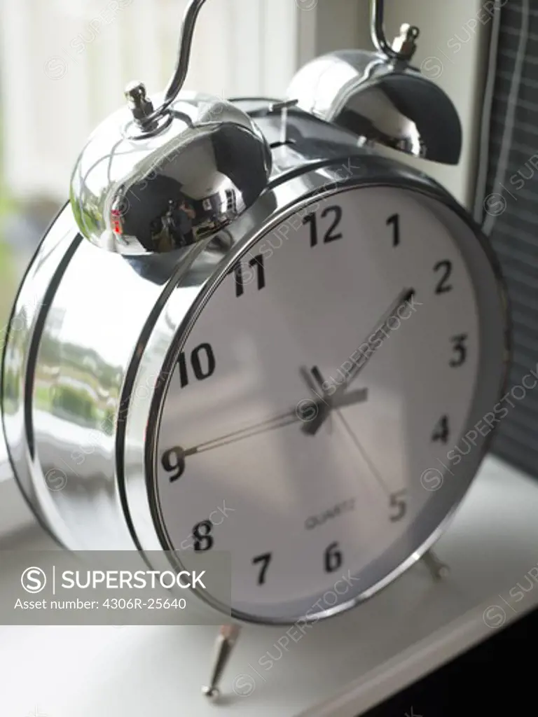 Close-up view of old-fashioned alarm clock on windowsill