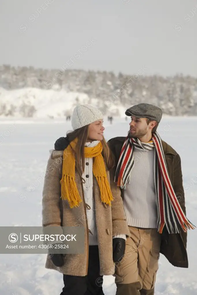 Mid adult couple and walking in winter landscape