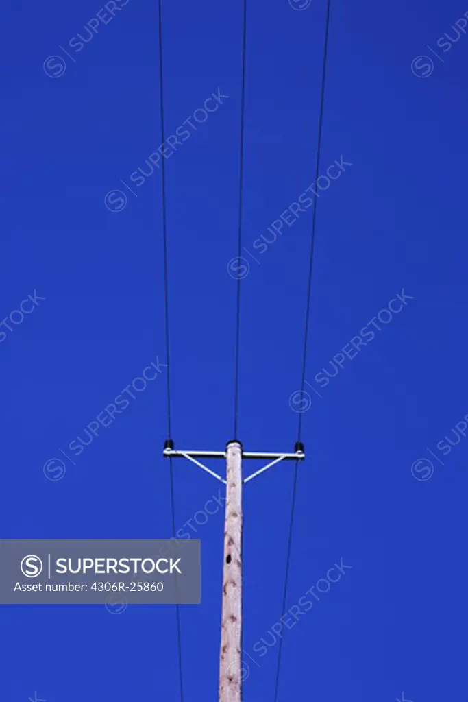 Telegraph pole against blue sky