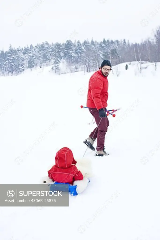 Father and daughter playing with toboggan