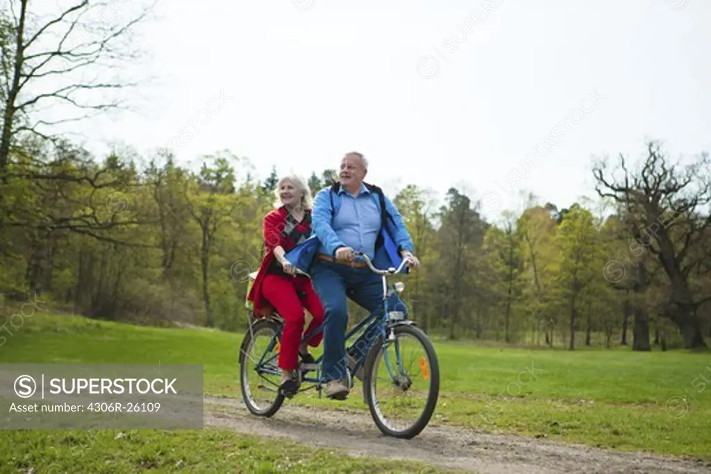 Senior couple riding on tandem bicycle