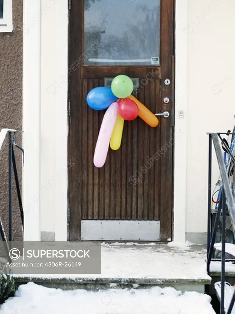 Colorful balloons hanging on door