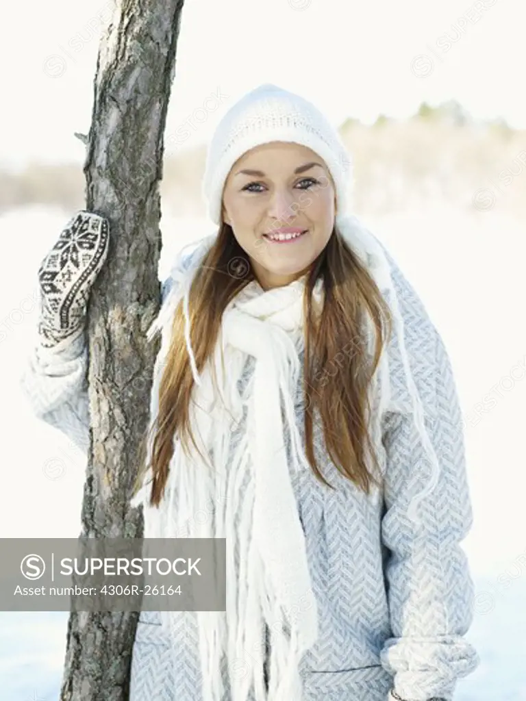 Portrait of young woman wearing white hat and white wooly scarf
