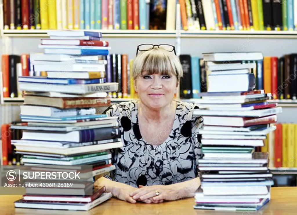 Mature woman surrounded by books in library