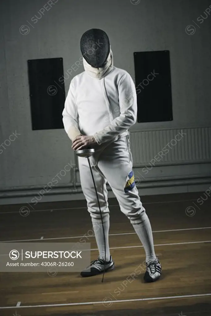 Portrait of fencer wearing face guard in sports hall