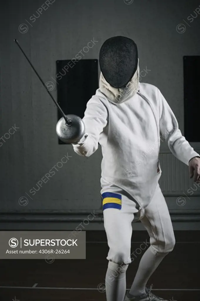 Male fencer in sports hall