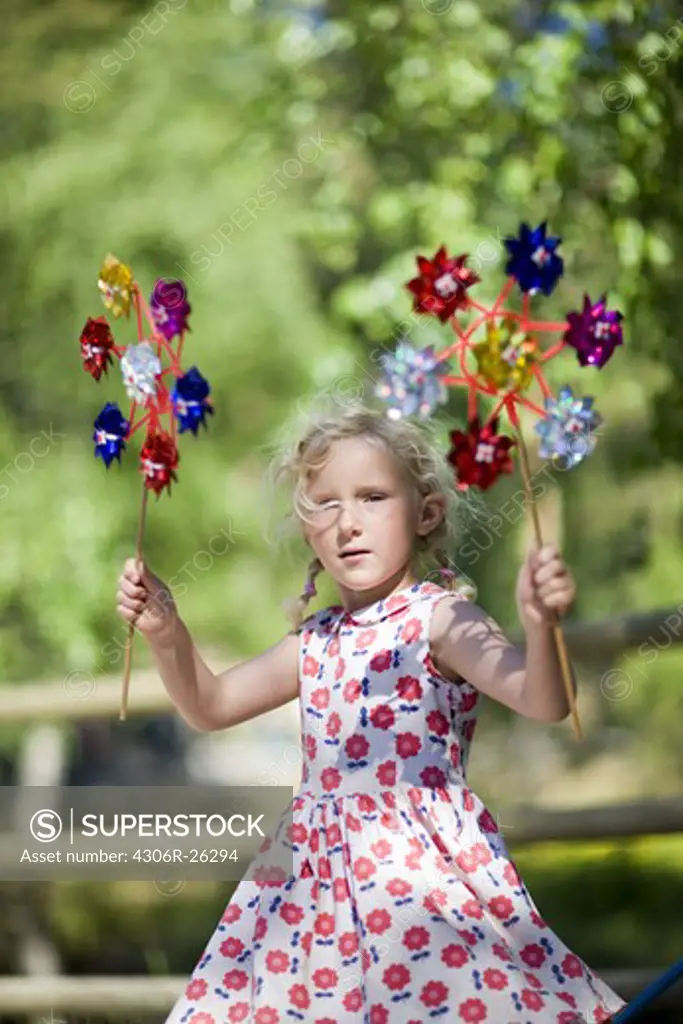 Portrait of girl holding paper windmill toys