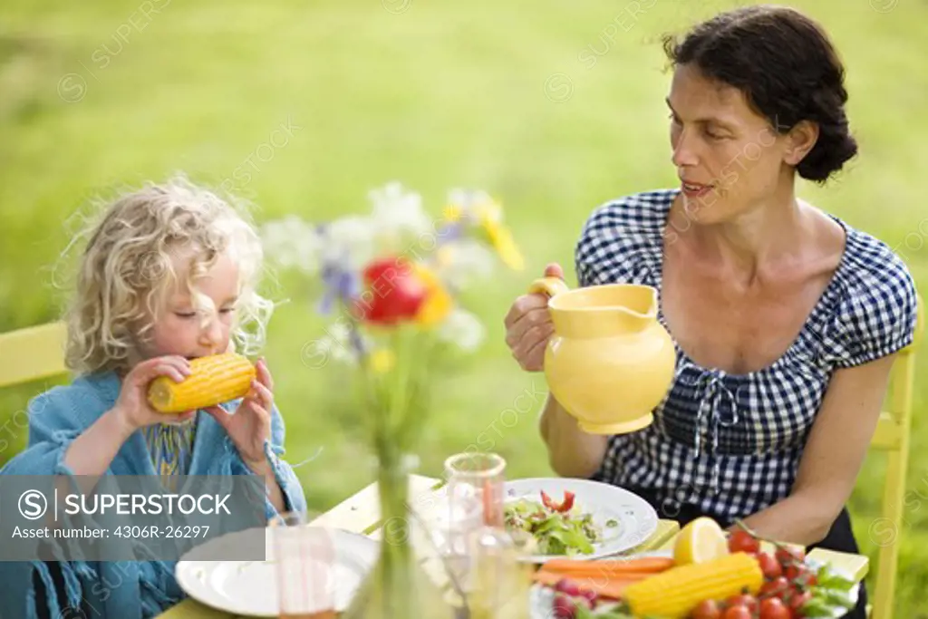 Mother and daughter eating outdoors