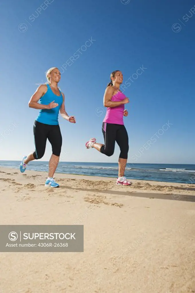 Two women jogging on beach