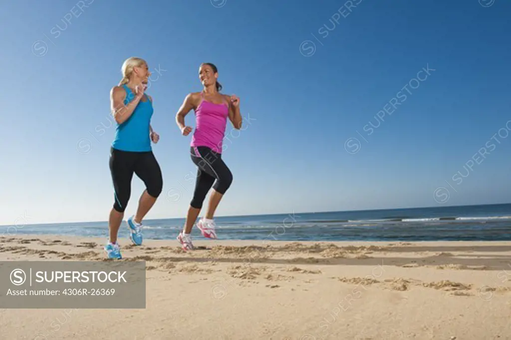 Two women jogging on beach