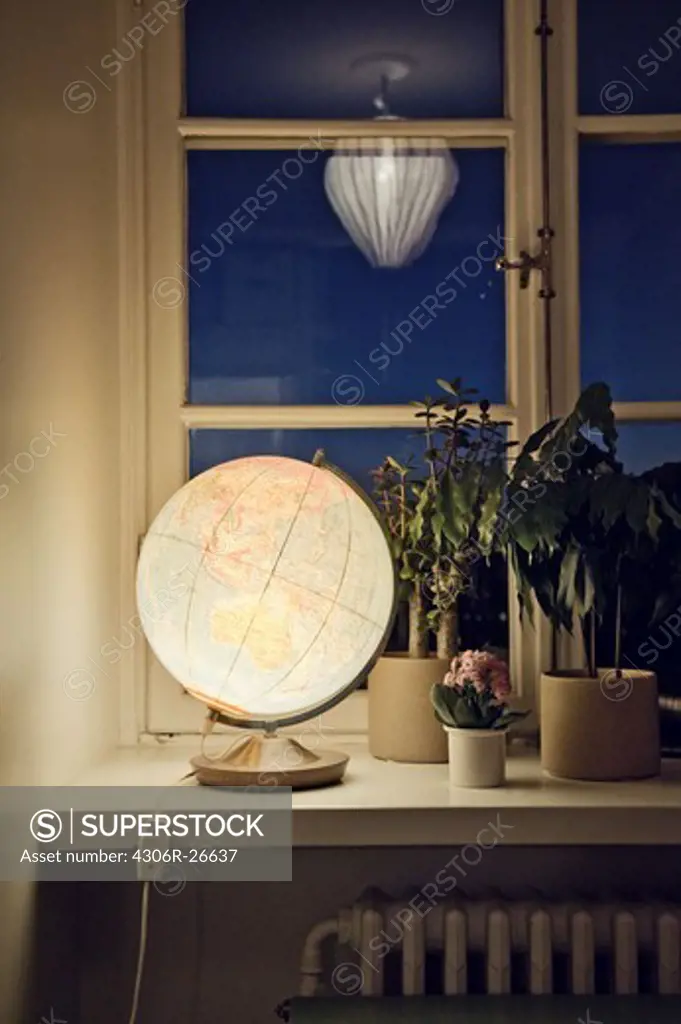Illuminated globe on window sill